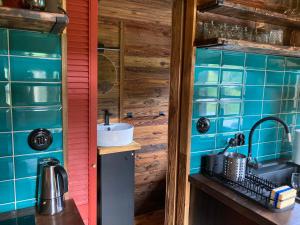 a kitchen with blue tiled walls and a sink at Domek Samice in Samice +63 photos