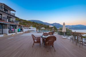 a table and chairs on a deck with a view of the ocean at Hamarat Otel in Kaş