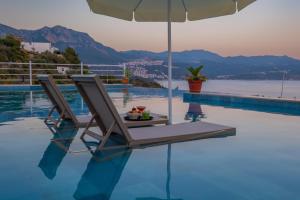 a lounge chair with an umbrella next to a swimming pool at Hamarat Otel in Kaş