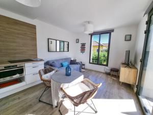 un soggiorno con un divano e un tavolo di La Fossette - T2 avec terrasse, parking et wifi a Le Lavandou