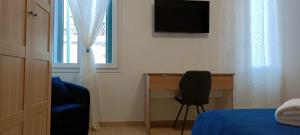 a bedroom with a bed and a desk and a television at Arcobaleno Rooms Mestre-Venezia in Mestre
