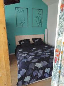 a bedroom with a bed with a blue wall at Espace Atypique détente, bien-être in Saint-Clair-de-la-Tour
