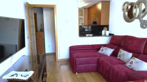 a living room with a purple couch and a kitchen at En Ribeira para 4 céntrico con parking in Ribeira