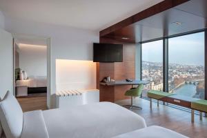 a bedroom with a bed and a desk with a view at Radisson Blu Iveria Hotel in Tbilisi City