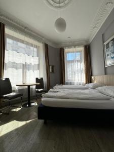 a large bedroom with a large bed and a table at Hotel Kieler Hof am Hauptbahnhof - Hamburg Central Station in Hamburg
