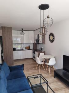 a living room with a blue couch and a table at Apartament Rejtana in Leszno