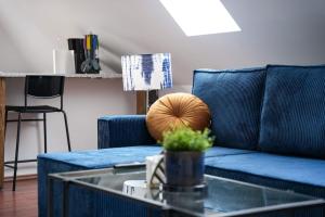 a blue couch in a living room with a glass table at Blue Skyline in Paderborn