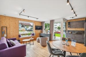 a living room with a purple couch and a table at Chalet LebensTraum im Zentrum in Oberstaufen