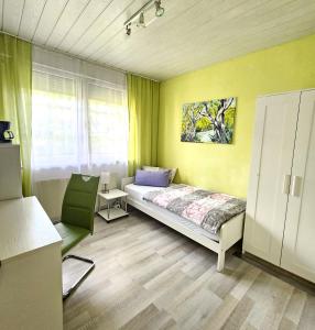 une chambre avec un lit et une chaise dedans dans l'établissement Pension Bunz, à Kelsterbach