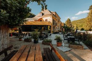 a group of wooden benches in front of a restaurant at Hotel Restaurant Le Cigalon in Waldbillig