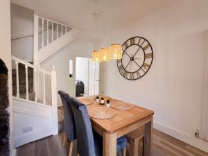 a dining room with a table and a clock on the wall at Your Property Box Short Stays - Severn Street in Worcester