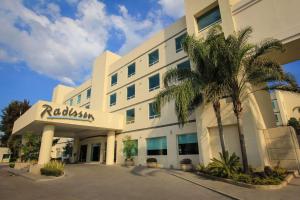 a hotel with a palm tree in front of it at Radisson Poliforum Plaza Hotel Leon in León