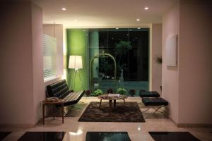 a living room with a table and chairs and a green wall at Radisson Poliforum Plaza Hotel Leon in León