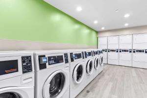 a laundry room with a row of washing machines at WoodSpring Suites South Houston Hobby in Houston