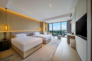 Postel nebo postele na pokoji v ubytování New Century Mansion Resort Hangzhou Xianghu Baoyi