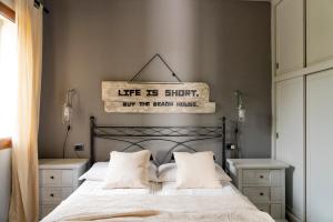 a bedroom with a bed with a sign that reads life is short theyre right at CASA OSALA in Orosei