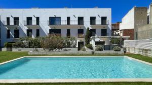 a swimming pool in front of a building at Darsena B 2-4 in L'Estartit