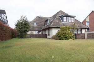 una casa con una valla y un patio en Haus Kerstin Duhnen Wohnung 8, en Cuxhaven