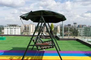 una silla con una sombrilla encima de un tejado en The Opulent siayapark apartments, en Nairobi 4 fotos más