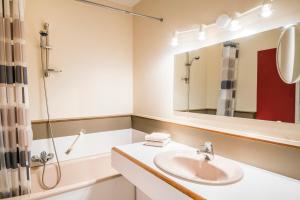 a bathroom with a sink and a shower and a mirror at Hotel Restaurant Le Cigalon in Waldbillig +33 photos