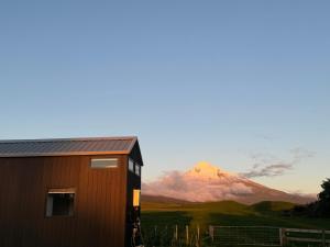 OkatoSacred Ground by Tiny Away的以山为背景的房子