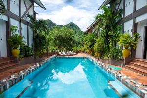a swimming pool at a resort with mountains in the background at Victory Road Villas in Phong Nha