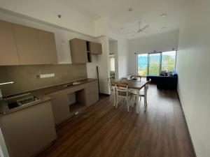 a kitchen and dining room with a table and chairs at Canterbury Golf Resort Apartments in Kahatuduwa