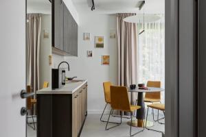 a kitchen with a table and chairs in a room at Villa Glamour Apartamenty In in Jurata