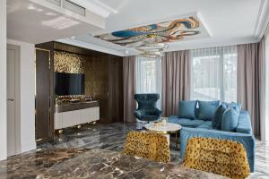 a living room with a blue couch and chairs at Villa Glamour Apartamenty In in Jurata