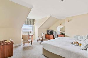 a bedroom with a bed and a table and chairs at Royal Beacon Hotel in Exmouth