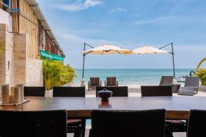 a table and chairs with a view of the beach at Beachfront 4BR Villa with Private Pool - Ocean Access in Chaloklum