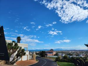 een weg in een stad met een blauwe lucht bij Cape Cottage in Kaapstad