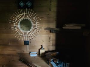 a mirror on the wall of a bathroom with a sink at Cabane dans les Arbres de Valmo'Insolite in Valmorel