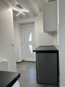 a kitchen with a black counter top and a door at Studio Cozy proche aéroport CDG in Claye-Souilly +2 photos