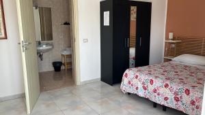 a bedroom with a bed and a bathroom with a sink at B&B Torre del lago 2 in Foce Varano