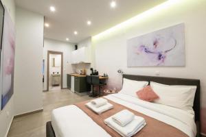 a bedroom with a large bed with two towels on it at DK Mini Studio White Tower in Thessaloniki