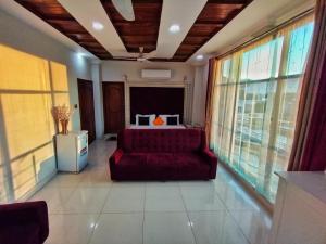 a living room with a bed and a red couch at Swat Hilton Hotel by Khan Familia in Swat