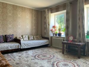 a living room with a couch and a window at Gulnara guesthouse in Kochkorka