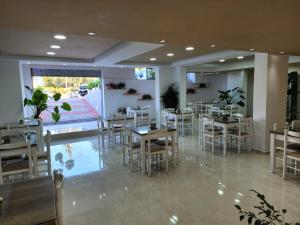 a dining room with tables and chairs in a restaurant at Ventus Hotel in Ksamil