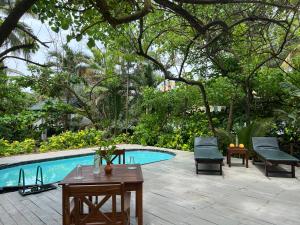 a patio with a pool and a table and chairs at Lohas Beach Villa in Kalutara