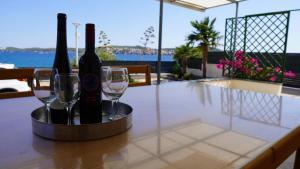 a table with two bottles of wine and two glasses at First Row to The Sea - Ideal for Families - Sea at Your Doorstep - House Sisko in Trogir