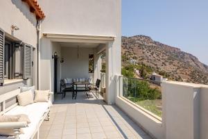 a balcony with a view of a table and chairs at Aurora Spinalonga Garden Cottage in Chavgas