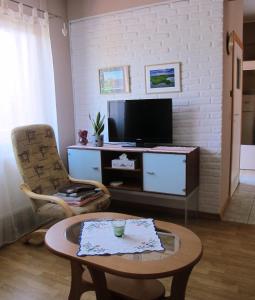 a living room with a tv and a coffee table at Apartament w małej wsi niedaleko jezior - Kaszëbsczi Nórcëk in Kamienica Szlachecka