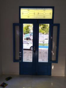 a blue door with two windows in a building at Pousada Nelly Medeiros in Carolina