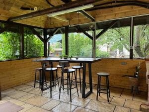 a bar in a screened in porch with stools at Pensiunea MIS in Bran