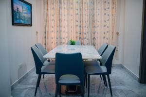 a dining room with a table and blue chairs at Serviced 3Bed Duplex in Oba Akinyele Street, off Rotimi Williams, Bodija in Ibadan