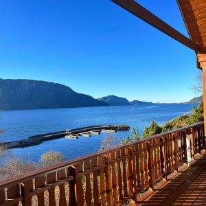 a view of a lake from a wooden balcony at Øen Hytter - Hytte 2 in Sørbø