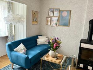 a blue couch in a living room with a vase of flowers at Residenz zu Caub - Rheinblick in Kaub
