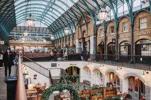 een overdekt winkelcentrum met mensen die erdoorheen lopen bij The Insta Playhouse - Covent Garden - by Frankie Says in Londen