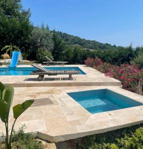 a group of three swimming pools in a yard at Maisonnette au calme in Montauroux